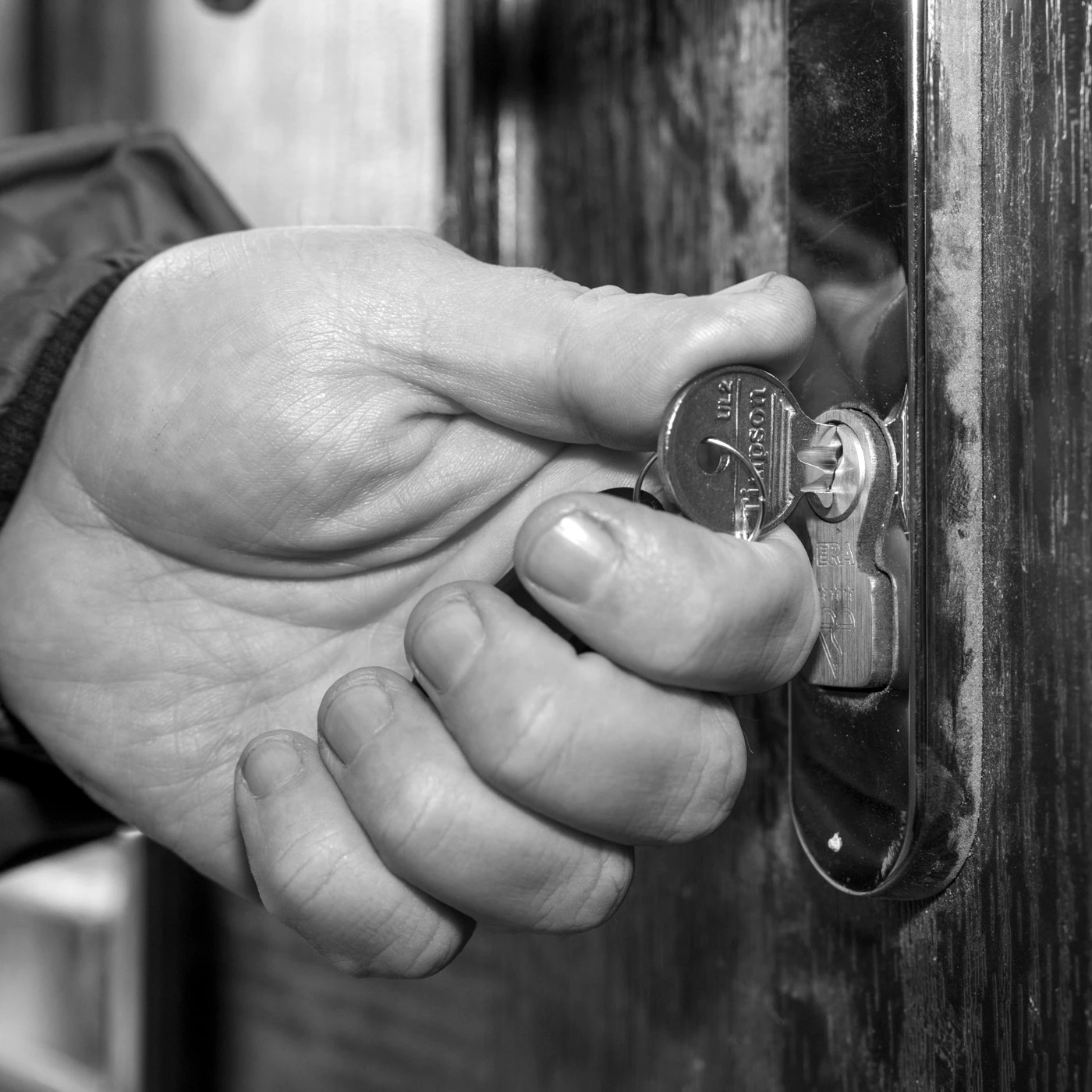hand with key opening a door